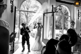 Bride and groom making a humorous entrance with party glasses and smoke effects at Palazzo Viviani in Monte Gridolfo, Rimini, Italy.